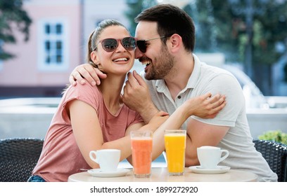 Flirting in a cafe. Beautiful loving couple sitting in a cafe drinking coffee and enjoying in conversation. Love, romance, dating
