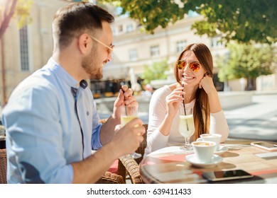 Flirting in a cafe. Beautiful loving couple sitting in a cafe enjoying in coffee and conversation. Love, romance, dating - Powered by Shutterstock