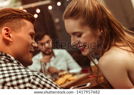 Flirting couple. Close-up face portrait of beautiful attractive young-adult cheerful joyful couple flirting with each other at the bar.