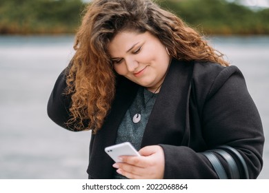 Flirting Plus Size Woman. Online Communication. Date Arranging. Enjoying Life. Cheerful Pleased Fatty Lady Typing Mobile Phone Walking Outdoor.