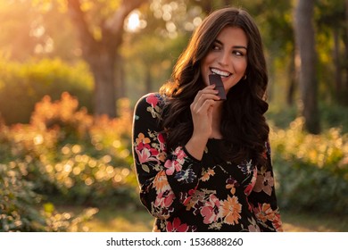 Flirty Elegant Beautiful Woman Eating Dark Chocolate In The Park In Autumn 