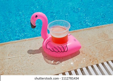 Float Flamingo Drink Holder With Beer In A Pool Party.