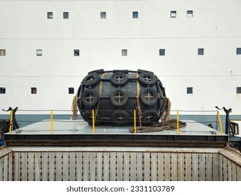Float A large black float sits on top of the deck.  Surrounded by chains and old tires.  Used for balancing ships while moored in port or in the middle of the sea and maritime transport concept.