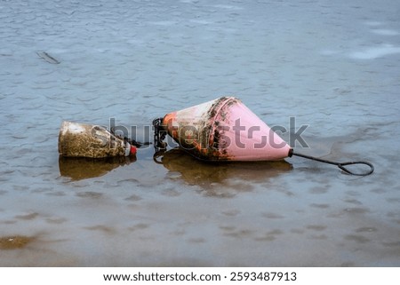 A float tied to an anchor lying on the bottom of a lake in winter during a lack of water inflow