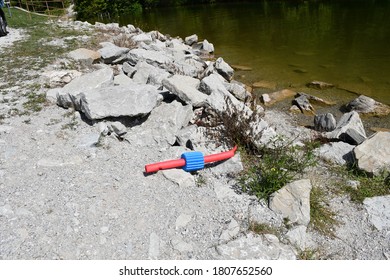 A floatation device left on the ground near a lake. The item is next to some rocks and grass. Picture taken in Bella Vista, Arkansas.