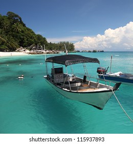 Floating boat in clear water at an island.