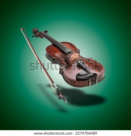 Floating classical violin instrument  with shadows on green gradient background