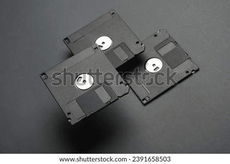Floating colored retro 80s floppy disks on dark gray background. Conceptual pop, creative layout