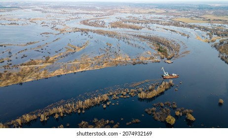 Floating crane on the river. Dredging crane working near shore. Conservation river flow. Nature, river, sky, clouds. Cleaning the bottom of the river.