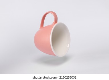 Floating empty ceramic cup on white background with shadow