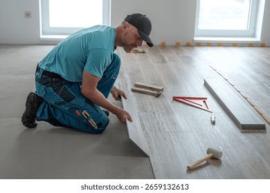 Floating floor work. The worker inserts the board of vinyl plank to the click system of Floating floor. 