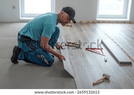 Floating floor work. The worker inserts the board of vinyl plank to the click system of Floating floor. 