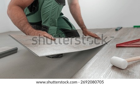 Floating floor work. The worker inserts the board of vinyl plank to the click system of Floating floor. 