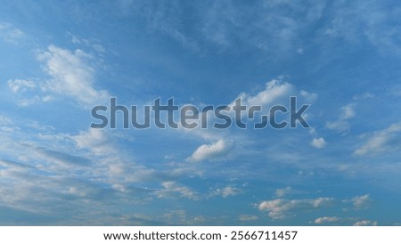 Floating fluffy clouds. Two layers of cloudiness. Blue summer sky with clouds moving in different directions. Time lapse.