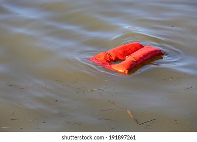 Floating Life Jacket. An Overboard Lifejacket Drifting On The Water. 