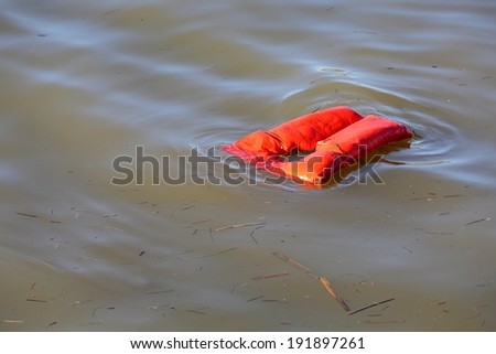 Floating Life Jacket. An overboard lifejacket drifting on the water. 