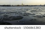 Floating melting ice on Neva river at dusk with Peter-and-Paul Fortress in the background, St. Petersburg, Russia