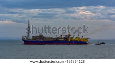 Floating production, storage and offloading (FPSO) vessel for oil and gas treatment with tugboats at the South China sea