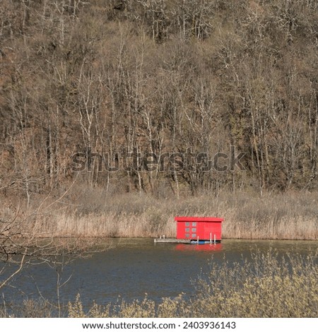 floating red cabin on a lake in winter