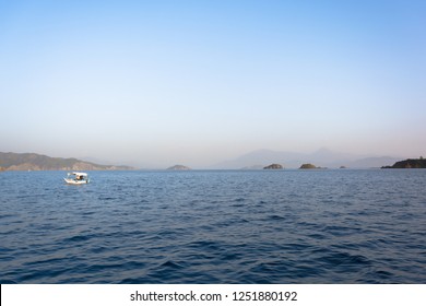 Floating Small Fishing Boat On Sea With Old Couple