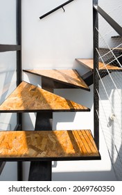 A Floating Staircase In The Shape Of Triangles And Rectangles Made Of MDF Material, Metal Frame And Railing Of Thin Metal Cables