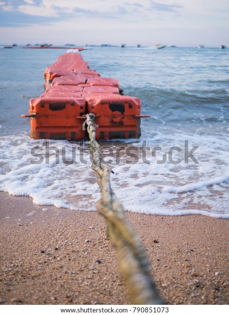 Floating wave breaker and\
rope on beach