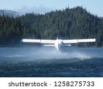 A floatplane is taking off at the remote floating village and marina Sullivan Bay, British Columbia. The location is about 30 miles from Port Hardy across Queen Charlotte Strait and has no road access