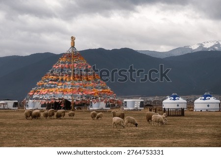Flock of sheeps and Prayer Flags dar-ding on a grassland at Napahai Lake under warm sunrise, Shangri-la, Yunnan, China
