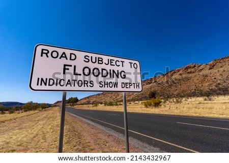 Flood warning sign on outback Australian road. Alice Springs, Northern Territory.