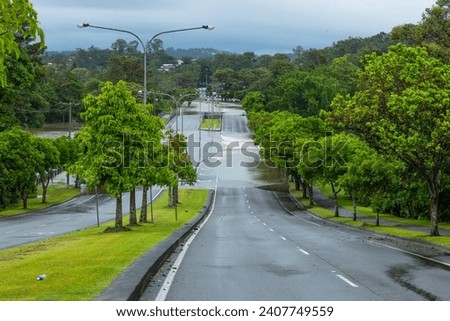 Flood water flowing in flood over a dual carriageway road after heavy storms on the Gold Coast in Queensland, Australia.