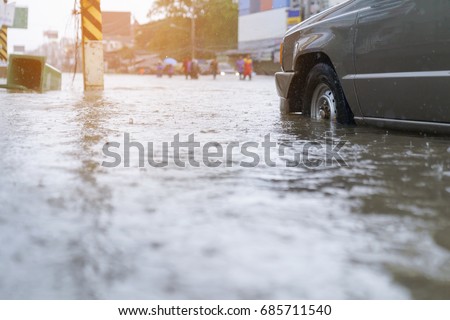 flood water - people walking in the rain on flooded road