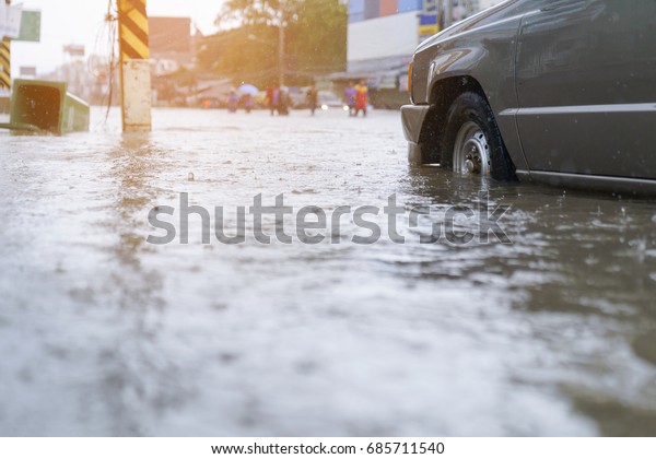 flood\
water - people walking in the rain on flooded\
road
