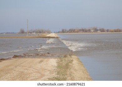 Flood Waters Rushing Over Rural Road On A Windy Day