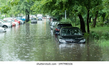 Flooded cars on the street of the city. Street after heavy rain. Water could enter the engine, transmission parts or other places. Disaster Motor Vehicle Insurance Claim Themed. Severe weather concept - Shutterstock ID 1997980106