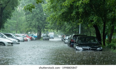Flooded cars on the street of the city. Street after heavy rain. Water could enter the engine, transmission parts or other places. Disaster Motor Vehicle Insurance Claim Themed. Severe weather concept - Shutterstock ID 1998805847
