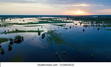 Flooded country road and flooded meadow. Flying above flooded country road in beautiful meadow at sunset. Beautiful meadow landscape in Ukraine. Aerial view.