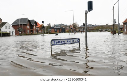 Flooded Danish city streets and traffic lights under storm surge and a sign with directions to the southern harbour dock