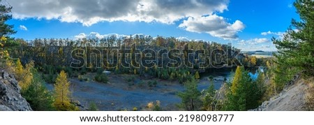 flooded quarry with trees around in autumn
