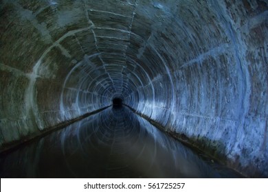 Flooded Round Sewer Tunnel Is Reflecting In Water