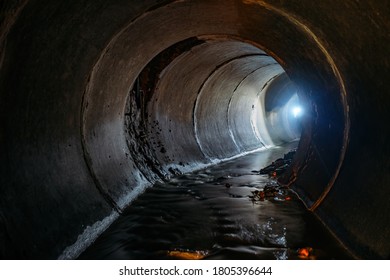 Flooded Round Sewer Tunnel With Water Reflection