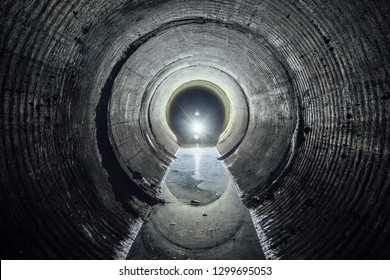 Flooded round underground drainage sewer tunnel with dirty sewage water