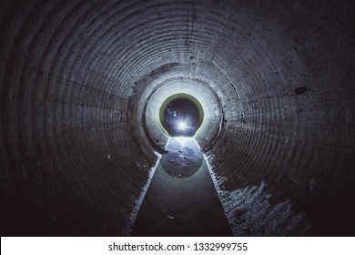 Flooded round underground drainage sewer tunnel with dirty sewage water.