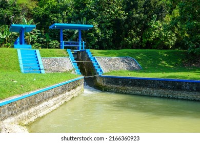 Floodgates that stem the irrigation river from the dam that divides the flow to several locations leading to rice fields so that they can be harvested. Controlled by manual and gear. Countryside.