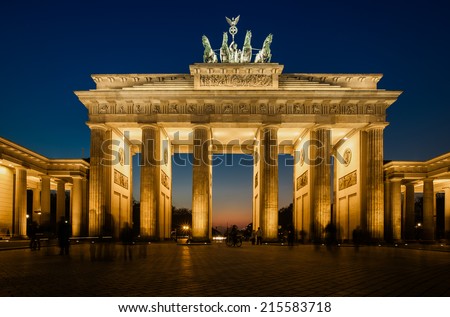 The floodlit Brandenburg Gate in Berlin with a few fleeting shadows of anonymous Berliner's - Symbol of Germany.