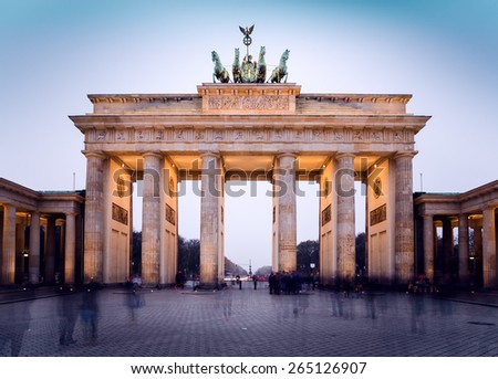 The floodlit Brandenburg Gate in Berlin with a few fleeting shadows of anonymous Berliner's - Symbol of Germany.