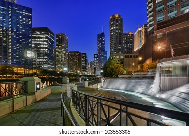 Floodlit Centennial Fountain And River Side Walk In Chicago At Night