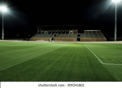 Floodlit Sports Stadium With Freshly Cut Grass And Bright Flood Lights 