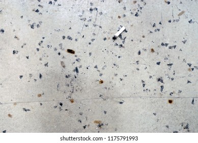 Floor Covered With Lots Of Cigarette Burn Marks And A Leftover Cigarette Butt