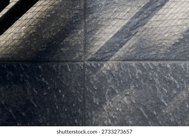 Floor features bold diagonal shadows from a railing, creating a moody geometric composition. The interplay of light and texture evokes urban architecture and a calm, cool ambiance.