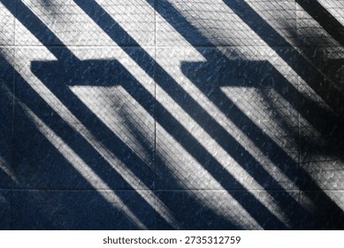 Floor features bold diagonal shadows from a railing, creating a moody geometric composition. The interplay of light and texture evokes urban architecture and a calm, cool ambiance.
